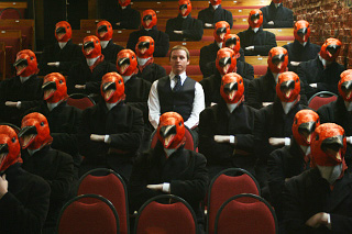 Robert sat amongst an audience of orange penguins